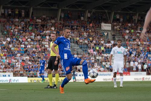 Šimon Falta zpracovává balón s rozhodčím v zádech